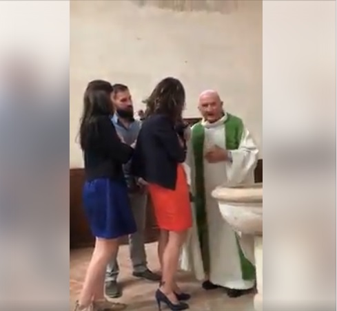 أمام والديه.. رجل دين مسيحي يصفع رضيعا بقساوة! (فيديو)